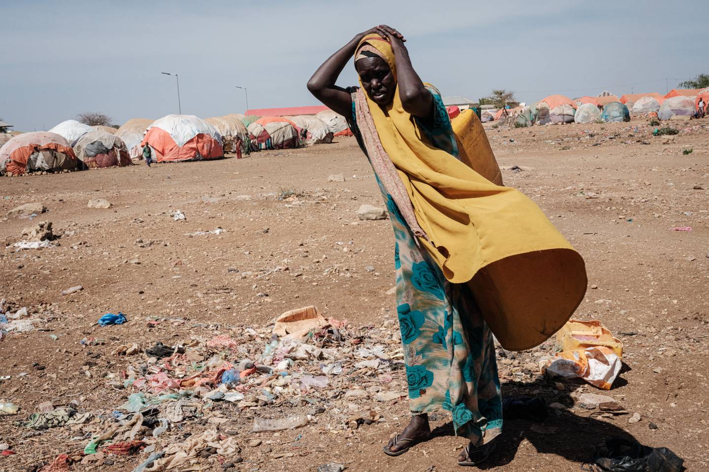 امرأة تحمل حاوية مياه في مخيم للنازحين داخلياً في بيدوة بالصومال.  وكالة فرانس برس